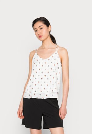 Top branco sem mangas com padrões florais coloridos, decote em V e alças finas ajustáveis, combinado com calções pretos. Textura suave, design fluido.