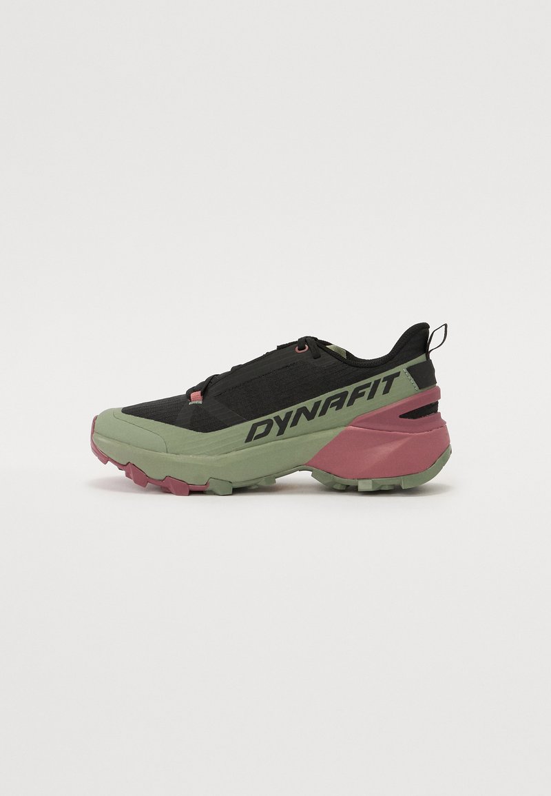 Trail running shoes with a black upper, green midsole, and pink outsole. Features textured fabric, laces, and prominent "DYNAFIT" branding.