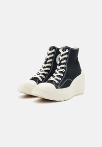 Zwarte canvas hoge sneakers met witte veters, een witte rubberen zool en contrasterende stiksels. Voorzien van een ronde neus en een ontwerp met wiggen.