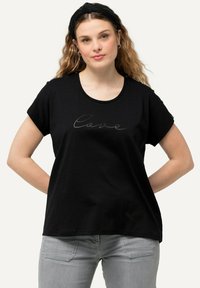 Camiseta negra de manga corta, con cuello redondo, que presenta la palabra "Amor" en una impresión sutil, estilo manuscrito, en el frontal.
