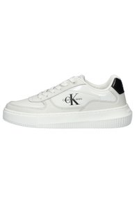 Baskets basses blanches avec logo Calvin Klein Jeans sur le côté, lacets blancs et patch noir au talon, dotées d'une semelle blanche épaisse.