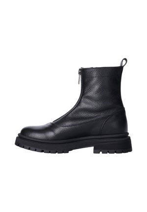 Stivaletto in pelle nera con suola spessa, cerniera laterale e linguetta sul retro, mostrato dal lato esterno.