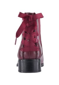 Stivale alla caviglia in pelle bordeaux con tacco nero testurizzato e lacci coordinati. Presenta cuciture verticali e una punta rotonda.