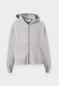 Felpa con cappuccio grigia, dotata di zip completa, con dettagli in borchie lungo le maniche e tasche a marsupio. Materiale in cotone morbido.