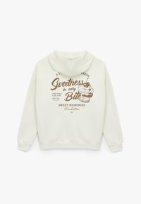 Witte hoodie met een bruine grafische print met tekst en een cupcake-illustratie, gemaakt van zacht materiaal met geribbelde boorden.