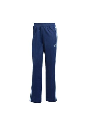 Pantalones deportivos Adidas azul marino con cintura elástica, rayas blancas laterales, bolsillos con cremallera y logo de trébol Adidas en el muslo.