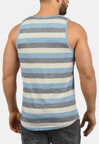 Gestreept tanktop met horizontale lijnen in blauw, grijs en crème. Gemaakt van een lichtgewicht stof met een afgeronde zoom en brede schouderbanden.