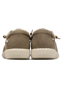 Scarpe in suede marrone con una suola testurizzata di colore crema. Presentano una forma arrotondata, una parte superiore morbida e una chiusura a toggle per una facile regolazione.
