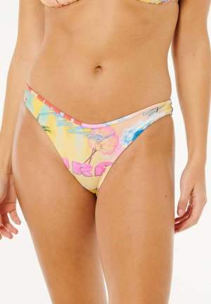 Donna che indossa slip bikini a vita alta con stampa tropicale pastello e testo rosa, che mostra la zona addominale e la parte superiore delle cosce.