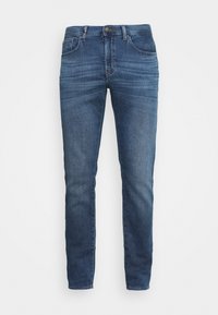 Blå slim-fit jeans med fem fickor och knappstängning, utrustade med subtila urtvättningar och whiskeringdetaljer på framsidan av låren.