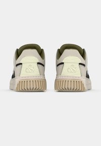 Sneakers cu un exterior bej deschis, accente negre și un guler verde măsliniu. Talpă texturată cu caneluri verticale și detaliu reflectorizant pe călcâi.