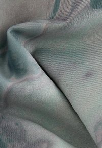 Kareda kangas pehmea, siledal pinnal tuhmades rohelises toonis, millel on keerulised ebakorrapärased mustrid ja kerge läige.