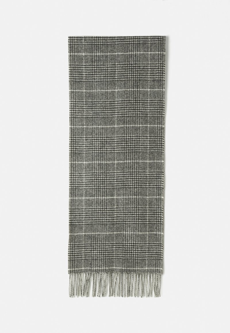 Écharpe à carreaux gris avec des motifs noir et blanc et des franges aux deux extrémités, posée à plat sur un fond blanc.