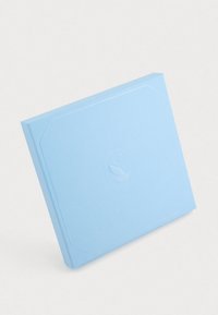 Caderno quadrado azul claro com uma capa texturizada, apresentando um logótipo de cisne em relevo e contornos geométricos subtis nas bordas.