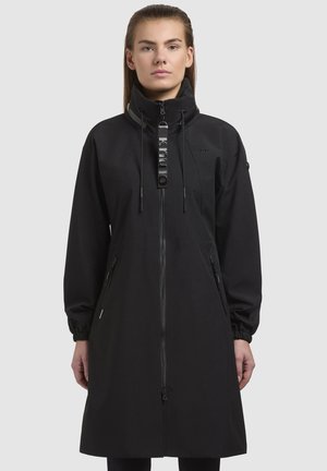 Zwarte lange jas met een hoge kraag, ritssluiting aan de voorkant en een trekkoord. Voorzien van ritssluitingen in de zijzakken en elastische manchetten. Glad stoftextuur.
