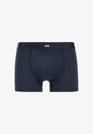 Marineblaue Boxershorts mit glatter Textur, elastischem Bund und kontrastierendem Logo. Sie zeichnen sich durch eine taillierte Passform und eine Länge bis zur Mitte des Oberschenkels aus.