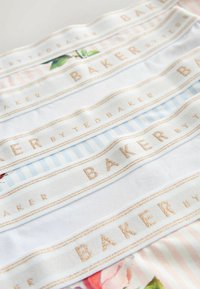 Bandes de tissu blanches et à rayures pastel arborant un texte brodé en or "BAKER BY TED BAKER" ainsi que des motifs floraux subtils.