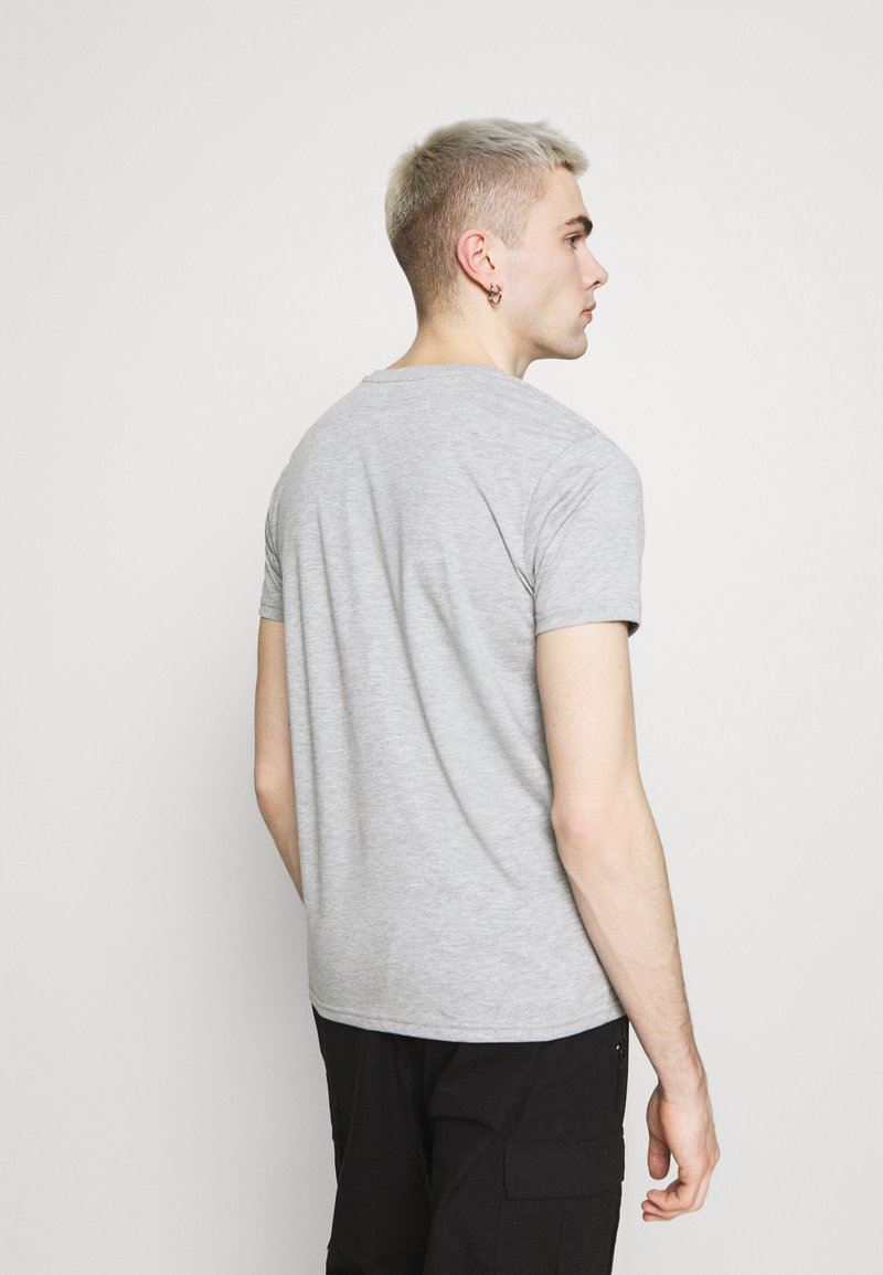 Camiseta gris de manga corta con cuello redondo, hecha de una suave mezcla de algodón, que presenta un diseño ajustado y una textura suave.