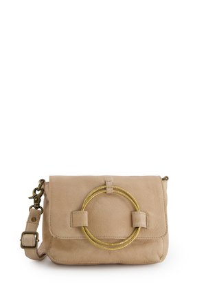 Beige leren crossbodytas met klep, voorzien van een grote gouden ronde metalen ring en een verstelbare riem met gesp.