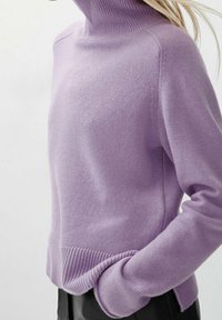Pull en col roulé violet en matière tricot douce, avec un col et des poignets côtelés, un fit décontracté et des poches latérales.