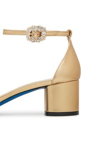 Gold leather heel sandal with a block heel, ankle strap featuring a decorative rhinestone buckle, and contrasting blue sole.