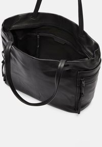 Czarna skórzana torba na ramię z dwoma uchwytami, zamykanymi kieszeniami, gładką fakturą i otwartą górą, z przestronnym wnętrzem i minimalistycznym wzornictwem.