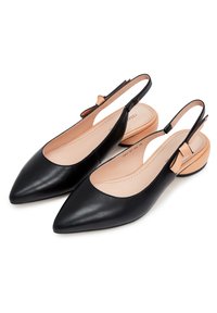 Scarpe slingback in pelle nera con punta affusolata, lati aperti e un piccolo dettaglio in beige sul tacco. L'interno è di un colore chiaro e morbido.