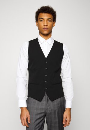 Black tailored vest with a V-neck, five-button front, and two front pockets, paired with a white shirt and gray checked trousers.