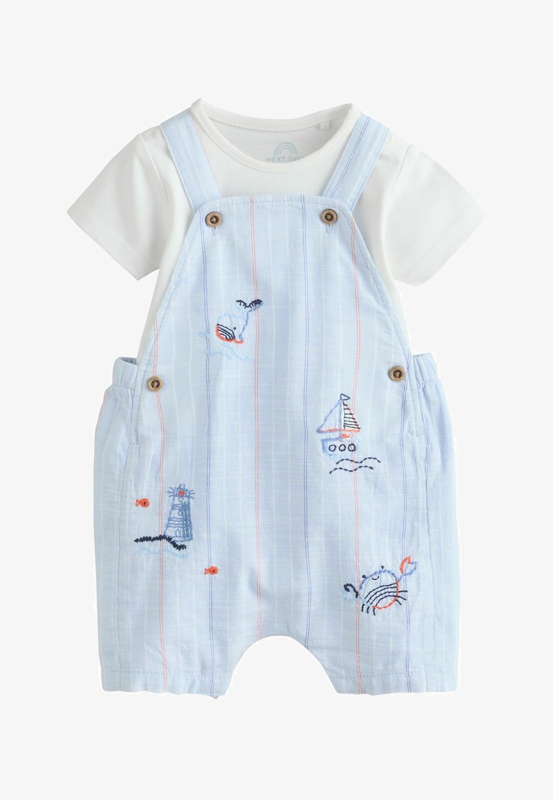 Chemise blanche à manches courtes avec une salopette à rayures bleu clair ornée de motifs brodés représentant une baleine, un voilier, un phare, un poisson et un crabe.