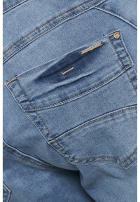 Heledsinine denim, millel on taga tasku, millel on kerge pleekimine, tugevdatud õmblused ja bränditud metalltag. Sile tekstuur klassikalise lõikega.