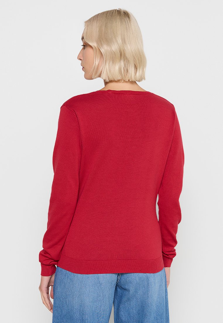 Roter gestrickter Pullover mit langen Ärmeln, rundem Halsausschnitt und gerippten Bündchen und Saum. Einfaches Design mit glatter Textur.
