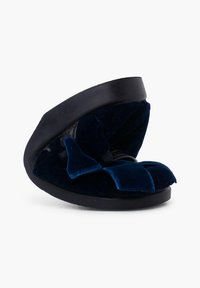 Sandalia deslizable de terciopelo azul marino con una suela negra estructurada y un detalle de lazo decorativo en la parte delantera, con un acabado suave y texturizado.