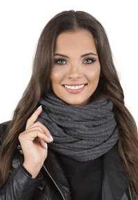 Grå strikket infinity-scarf med et tekstureret mønster, båret løst om halsen, komplementeret af en sort læderjakke.