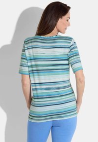 T-shirt à manches courtes avec des rayures horizontales dans des nuances de bleu et de vert. Tissu lisse avec une coupe décontractée et un col arrondi.
