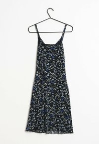 Musta kukallinen mekko, jossa sinisiä ja valkoisia kukkia, koristeellinen pitsireunus, säädettävät hihnat ja laskeutuva siluetti aaltoilevalla helmalla.