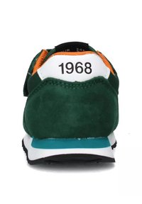 Sneaker verde in suede con accenti bianchi e arancioni, caratterizzata da una intersuola blu, suola nera e il numero "1968" sul retro.