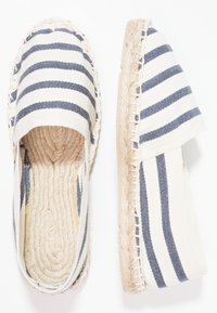 Gestreifte Espadrilles in Beige und Marineblau, mit Oberteil aus Canvas, runder Zehenform und Jutesohle mit geflochtenen Akzenten entlang des Randes.