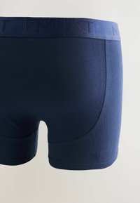 Boxer da uomo blu navy con cuciture sottili e una vita coordinata impressa con il nome del marchio "NEXT".