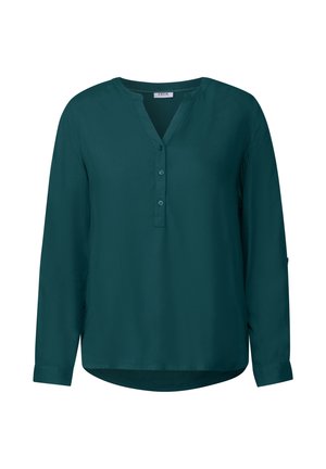 Blusa verde a maniche lunghe in un materiale morbido. Presenta una scollatura a V, una chiusura con bottoni e maniche con polsino e orlo arrotondato.