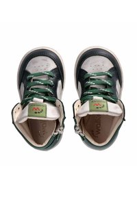Scarpe alte in pelle verde e nera con accenti in pelle bianca a contrasto, punte testurizzate e lacci verdi. Presenta un'etichetta con logo.