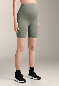 Nosečniške kolesarske kratke hlače v mehkem olivno zelenem materialu, ki imajo visok pas, ki omogoča udobno nošenje rastočega trebuščka, ter oprijet kroj.