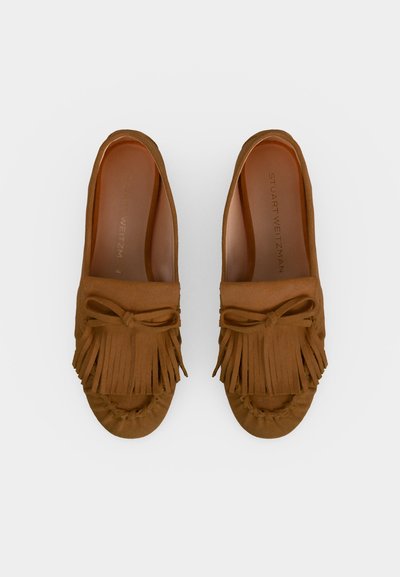 Mocassins en daim marron avec des détails de franges et de nœuds, semelles plates et bouts arrondis, montrés côte à côte vus de dessus.