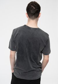 Gray cotton t-shirt with a relaxed fit and short sleeves. The fabric has a soft, slightly textured appearance with a round neckline.