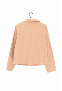 Ljusbeige långärmad skjorta med krage, med en något croppad design och slät textur. Inga synliga mönster eller hårdvara.