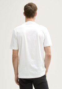 Hvid T-shirt med korte ærmer og rund halsudskæring, lavet af glat stof, med lige snit og uden synlige mønstre eller accenter.