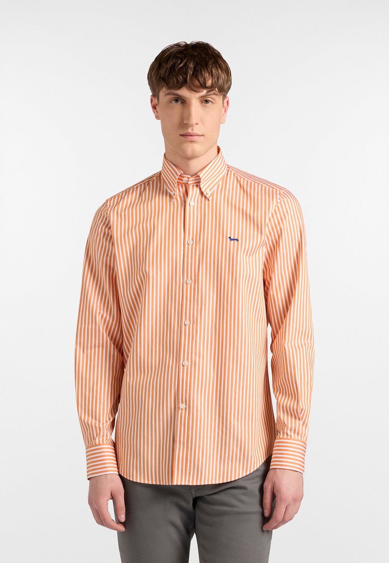 Orange- und weiß gestreiftes Langarmhemd mit einem Button-Down-Kragen und einem blauen Akzentlogo auf der Brust. Glatte Stoffoberfläche.