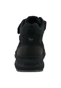 Černá atletická bota s texturovaným povrchem, suchým zipem a zesílenou patou. Obsahuje malé logo a pevnou gumovou podrážku.