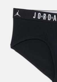 Čierne bavlnené slipy s bielym logom Jordan a nápisom na elastickom pásku. Hladká textura a klasický strih slipov.