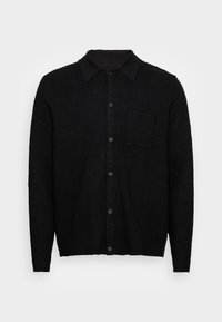 Cardigan noir à manches longues avec boutons, col et une poche poitrine, présenté sur un fond clair uni.