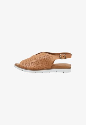 Sandalia slingback de cuero marrón claro con puntera abierta, con patrones geométricos perforados y suela de goma blanca con ranuras negras.